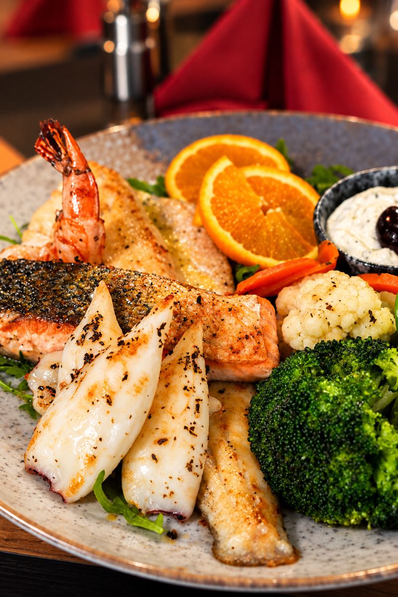 Fischplatte mit Garnelen, Calamari, Lachs und Gemüse